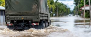 A military truck driving through deep floodwater