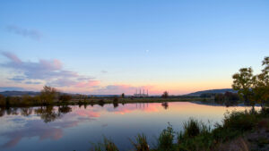 Panoramic View Of A Lake At Sunset With A Coal Power Station In Background